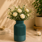 CraftLayer India Divine Vase in teal green with white roses on a warm tabletop